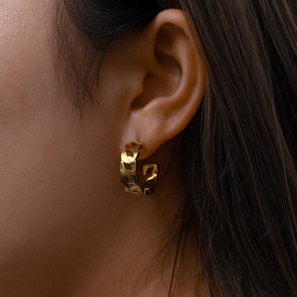 Model with dark hair wearing gold plated, hollow chain earrings